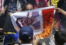 Protestierende Iraker verbrennen ein Poster mit dem Bild des iranischen Präsidenten